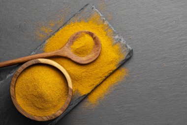 Tahta Kaşıklar Üzerine Renkli Baharatlar Curry, zerdeçal, ve Paprika Karanlık Sayfa Arkaplanda