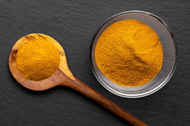 Tahta Kaşıklar Üzerine Renkli Baharatlar Curry, zerdeçal, ve Paprika Karanlık Sayfa Arkaplanda