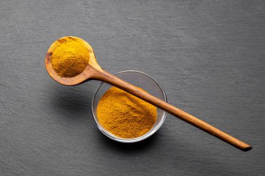 Tahta Kaşıklar Üzerine Renkli Baharatlar Curry, zerdeçal, ve Paprika Karanlık Sayfa Arkaplanda