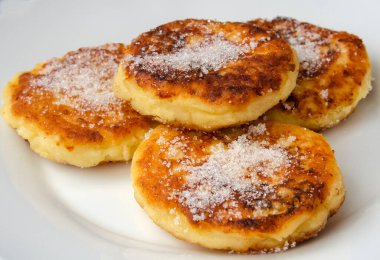 Syrniki (süzme peynirli gözleme veya lor böreği) beyaz seramik bir kasede, sağlıklı bir yiyecektir. Yiyecekler yakın plan..