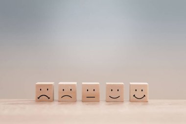 Tatmin edici emojileri gösteren tahta küpler müşteri hizmetleri değerlendirmesi ve geri bildirimi temsil ediyor