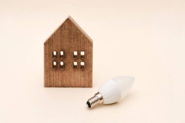 LED ampullü ahşap ev modeli, ev enerjisi ve elektrik tüketimi kavramı