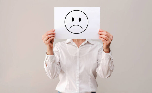 Анонимная женщина в белой рубашке прячется за чистым белым листом бумаги