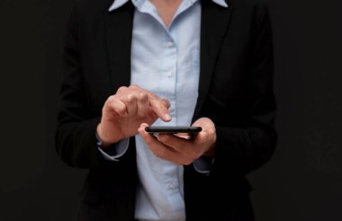 Akıllı telefon kullanan, interneti gezen, haberleri okuyan, siyah arkaplanda e-postaları kontrol eden İş kadınlarının kapatılması