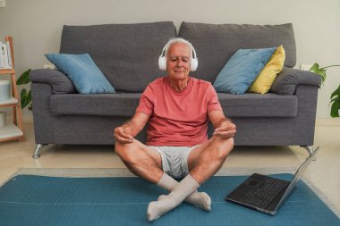 Son sınıf öğrencisi evde kulaklıkla meditasyon yapıyor.