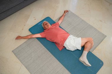 Son sınıf öğrencisinin ev egzersizinden sonra yoga minderinde dinlenmesi.