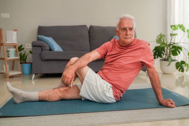 Son sınıf öğrencisi evde yoga minderinde esneme egzersizleri yapıyor.