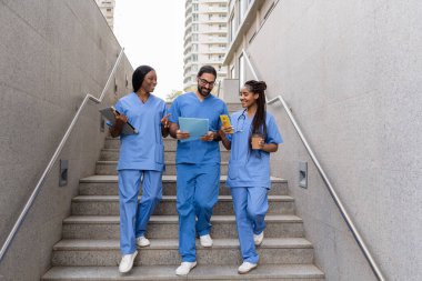 Hastane merdivenlerinden inen çok ırklı tıp öğrencileri.