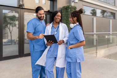 Çok çeşitli tıbbi ekipler hastanenin dışında tablet kullanarak hasta bilgilerini tartışıyor.