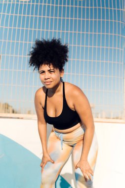 İspanyol kavisli kadın dışarıda antrenman yaparken mola veriyor.