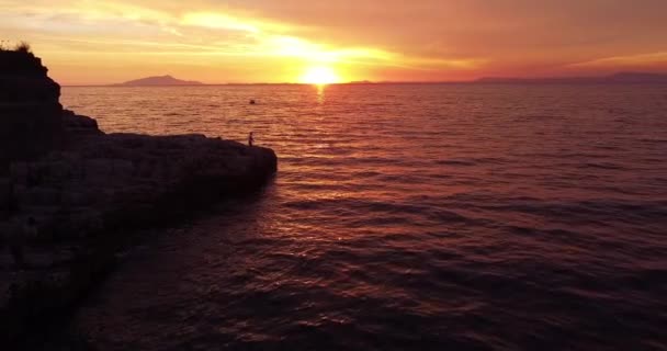 日没とソレントと地中海 海の近くで釣りをしている漁師の空中ドローン映像 背景の山のシルエット 波を静めろ 釣りとの映画的な眺め — ストック動画