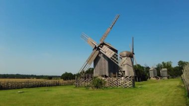 Antika ahşap yel değirmeni. Kırsalda eski bir yel değirmeni. Alternatif enerji. Rüzgar türbini hareket ediyor ve dönüyor. Çevre dostu kavram. Eko çiftliği, yeşil ekolojik dünya, çiftçilerde rüzgar çiftliği.