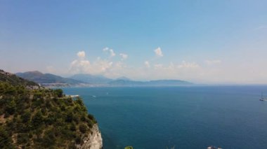 Amalfi sahilinin turistik manzarası ve yelkenli teknesi, Akdeniz 'de yatlar. Kayalık kayalıklar, mavi su, yüzen tekneler, yeşillik. Waterway limanı. Yüksek kalite 4k görüntü