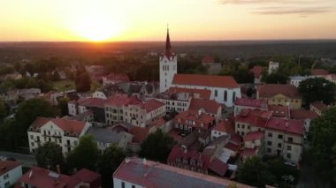Eski kasaba meydanında gün batımı manzarası. Eski kasabadaki Castle Meydanı, şehre odaklanmış. Gün batımının renkleriyle güzel kırmızı çatılar. Cesis, Letonya. Katedral bir meydanın önünde., 