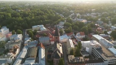 Şehirdeki eski kilisenin üzerinde uçan insansız hava aracı. Güzel Panoramik Uçuşlar Eski Avrupa kasabasında, Tartu. Entellektüel başkent, Kızıl çatılar. Ortaçağ şehri. Yürüyen insanlar, yeşil şehir. 