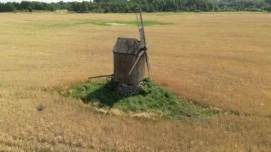Hava aracı görüntüsü. Yeşil manzaralı eski bir yel değirmeni. Alternatif enerji. Rüzgâr Güç Türbinleri Temiz Yenilenebilir Enerji üretiyor. Yenilenebilir enerji. Kırsalda eski bir yel değirmeni. 4K.