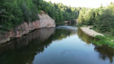 Kanocuların kayak yaptığı bir spor kanosuna insansız hava aracı atışı. Sahil kıyısında sakin bir nehir ve orman boyunca yelken açıyorlar. İnsanlar kanoyla denize açılıyorlar. Bir grup kanocu beyaz suda kürek çekiyor. Yüksek kalite 4k görüntü. 