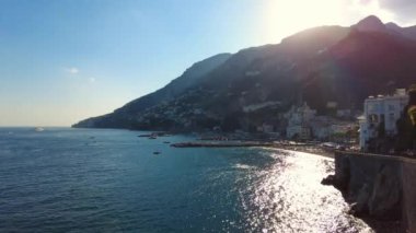 İtalya 'nın Amalfi sahillerine bakan görkemli günbatımı ya da gündoğumu. Akdeniz 'de yüzen insanlar. Dağlara doğru kayalık kıyı boyunca kıvrımlı bir yol. - Evet. Yüksek kalite 4k görüntü