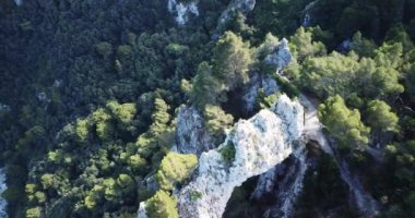 Arco Naturale hava görüntüsü, iki kaya sütunu arasında köprü oluşturan doğal kireçtaşı kemeri. Kayalıklar ve kaya oluşumu. Capri, İtalya. Yüksek kaliteli FullHD görüntüler