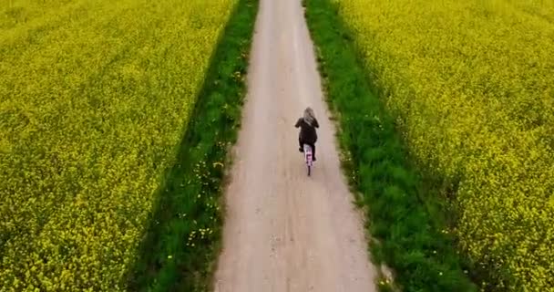 Περιστροφή Ποδηλάτου Δίπλα Χωράφι Κραμβόσπορους Ξανθιά Γυναίκα Κάνει Πετάλι Δίπλα — Αρχείο Βίντεο