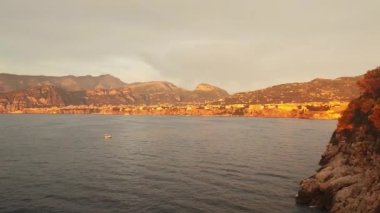 Napoli, İtalya, Vesuvios Dağı. Gün batımının renkleri dağlara yansıyor. Kayalık kayalıklarda kırmızı ve turuncu renkler var. Tyrhenian denizi ve Vezüv Yanardağı. - Evet. Yüksek kalite 4k görüntü