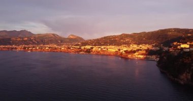 Şehir manzarası yaz günbatımı gökyüzü. Dağda parlayan güzel ışık huzmesi. Küçük Sorrento köyü zafer içinde. İtalya manzarası. Sabahın erken doğuşu, akşam batımı. Renkli sonbahar ağaçları. Havadan 
