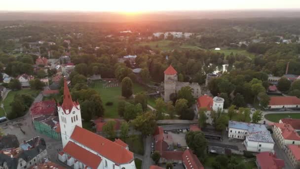 赤い屋根のある旧市街の空中ビュー 旧市街の眺めの上 日没の色と北欧の風景 ラトビアの都市セシス 歴史的にも文化的にも豊かな北欧の国 緑の風景 — ストック動画