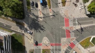 Çapraz yolda giden bir sürü araba var. Araba trafiği ve yoldan geçen insanlar. Trafik karayolu taşımacılığı. Kalabalık insanlar yürüyor, yayalar kavşaktan geçiyor. Gökdelenler binaları 