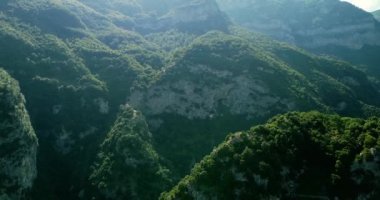 Hava aracı dağlardaki çam ağaçları üzerinde uçuyor. Uçurumlar, kayalar, tepeler, manzara, yeşil çimenler, bulutlar, doğa, Amalfi Sahili. Seyahat yerleri. Güzel vahşi manzara. Yeşil dağlar.