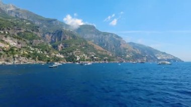 Güzel tropikal İtalyan plajının yanından tekne geçiyor. Zaman aşımı, hiper sapma. Napoli yakınlarında, Amalfi kıyısında çarpıcı bir turkuaz yeşil ve mavi su. Dağlık ada. Okyanus suyu. Koyu mavi. 