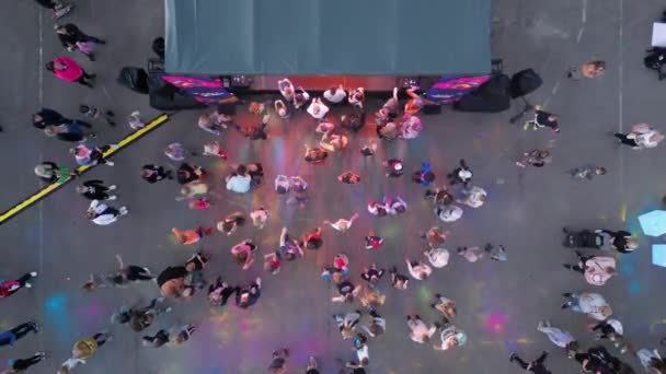 野外の音楽祭で大勢の人が集まっています 祭りの色で遊んでいる人 夏の夜のフェスティバルコンサート ストリートミュージックの大きなイベント 水の上のスタジアム 野外音楽祭 — ストック動画