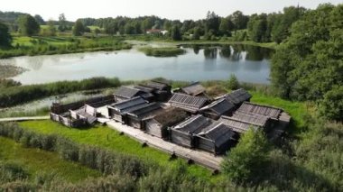 Araisi Gölü yerleşim alanı hava aracı görüntüsü, 9. yüzyılda inşa edilmiş. Letonya 'da Araisi Gölü' nün ortasındaki bir adadaki göl kasabası. Arkeolojik alan. Kuşlar uçuyor.. 