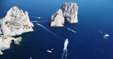 İtalya 'nın Napoli kıyısındaki Amalfi' nin Tyrrhenian deniz kıyısının insansız hava aracı görüntüsü. Lüks bir yat derin mavi okyanus denizinde yüzüyor. Akdeniz, güzel hava manzarası yatlar, botlar, dağlar.