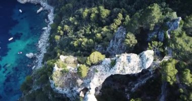 İtalya 'nın Napoli sahili, Napoli kıyısı, feribot turistlere açılan bir Amalfi körfezinde demirleyen iki kaya Aerial manzaralı yat sütunu ile tekneler arasında köprü oluşturan kireçtaşı kemeri. Feribot nakliyesi. 