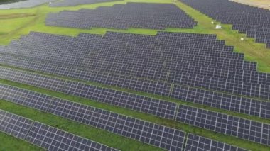 Yeşil enerji alanlarındaki ekoloji güneş enerjisi santrali panelleri. Sıraya dizilmiş yüzlerce güneş enerjisi paneli. Gün batımında temiz ekolojik elektrik. Yenilenebilir enerji konsepti üretimi. 4K. 