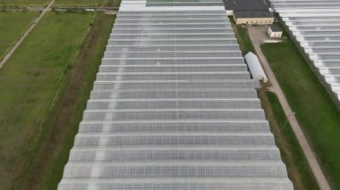 Industrial greenhouses aerial view. Flying Over Large Greenhouse, Modern High-tech Greenhouse View From Above. Glass Greenhouses for Growing Vegetables. Vegetable cultivation, agriculture industry.