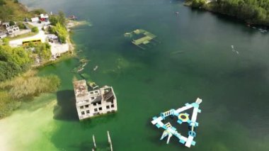Top down view of a house building Under Water. Flooded house. Village is flooded and under water. Left alone building. Blue green transparent water with paddle boards. flooded neighborhood. 