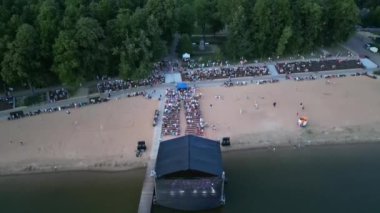 Açık havada bir müzik festivalinde büyük bir kalabalık. Gölün yakınındaki konser. Yaz akşamında festival konseri. Sokak müziği büyük olay, Stadyum su üstünde. Açık hava müzik festivali.