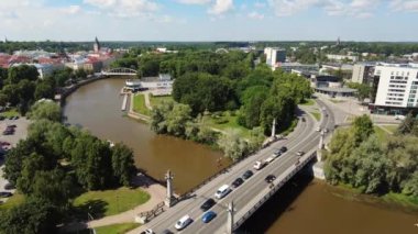 Timelapse view of a traffic in the city. Cars riding over the bridge. Cars, trucks and busses sitting in a traffic. City view. Green summer day. Clouds moving fast with timelapse. High quality 