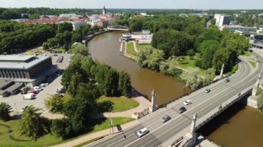 Timelapse view of a traffic in the city. Cars riding over the bridge. Cars, trucks and busses sitting in a traffic. Tartu, Estonia. City green view. Clouds moving fast with timelapse. High quality