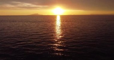 Majestic sunset or sunrise landscape. Beautiful cloudscape over the sea. Amazing light, pink and red sunset. Boats moving past. Red purple orange blue pink sunset sky cloud. Red sky, yellow sun.