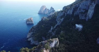 Aerial view of the three Faraglioni rocks off the Capri island. Aerial drone view of the Tyrrhenian sea coast of Capri, Italy. Coastal of azure Tyrrhenian Sea, Capri, island of Gulf of Naples, Italy.