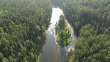 Aerial drone shot of forests and river valley with sunset in Sigulda, Gauja National Park, Latvia. There are many small islands located among the river. Flying over lakeland and forest. Pristine 
