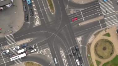 Top down aerial of cars drive at cross road. Heavy traffic in downtown streets. Pedestrians crossing busy intersection. Traffic highway transportation. Fast moving cars, trucks, buses and trains. 