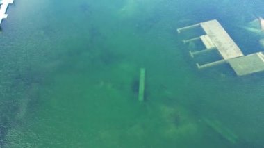 Village flooded and submerged underwater. Abandoned Rummu quarry, turquoise lake with underwater prison in the middle. Underwater city, at the bottom of lake. Old stone stairs under water.