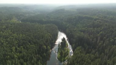 Aerial view of a island on a river with sunset colors. Aerial view of of islands on a fast moving river in Sweden, Finland. Mountain landscape Islands and green forest from above on a summer evening