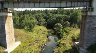 Aerial view of a train track bridge, railway bridge over the River Rauna, Latvia. Highest railway structure in Baltic countries. Endless railway without train. Empty straight single-way track.
