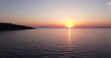 Colorful sunset above the sea surface with luxury yacht at golden pink sunset. Romantic colorful sunset at the sea. Gracefully sailing in the open sea toward sunset horizon. Italy landscape, Positano.