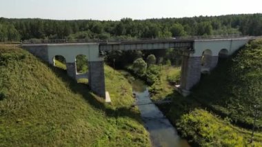 Aerial view of a train track bridge, railway bridge over the River Rauna, Latvia. Highest railway structure in Baltic countries. Endless railway without train. Empty straight single-way track. 