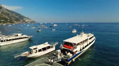 Arriving and Departing boat Boarding, abroad. Aerial drone footage of a speed boat ferry leaving and people entering boat. Passengers Boarding. Yacht anchored in tropical island bay with turquoise sea